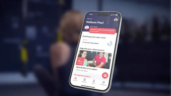Een smartphone toont een Nederlandse fitness-app met gebruikersdoelen en abonnementsopties.