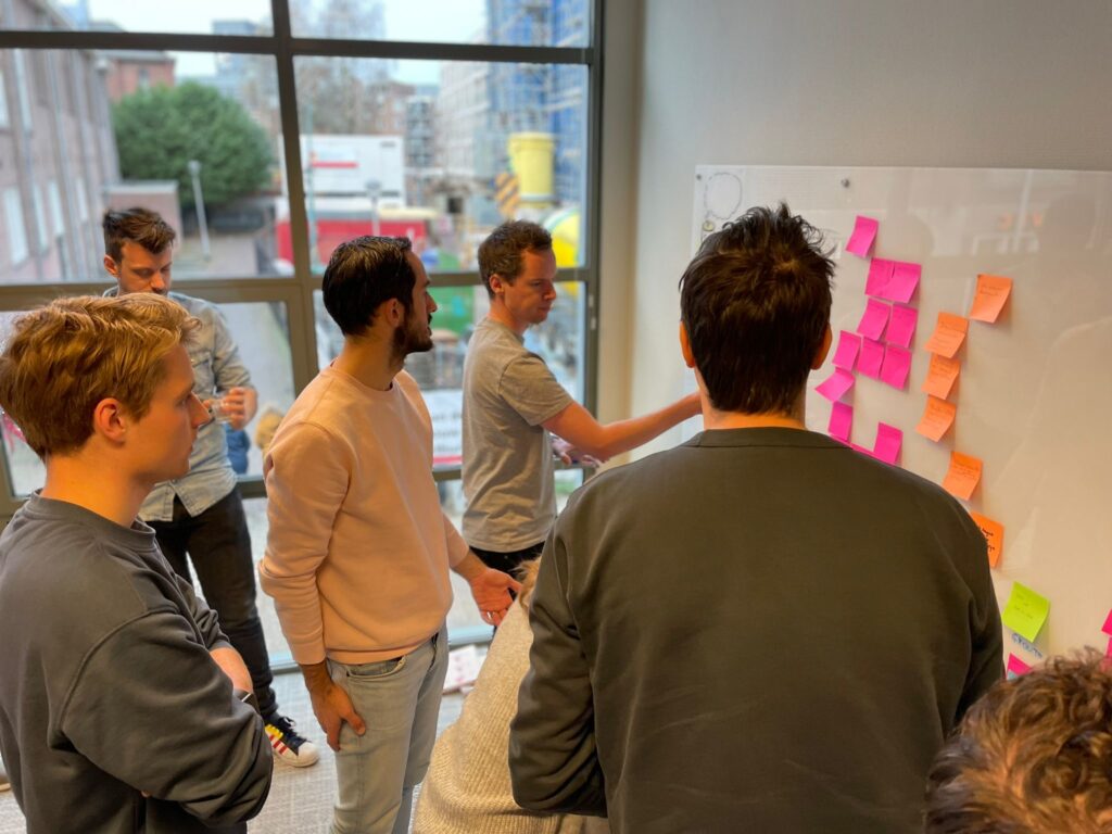 Het team van Stijlbreuk brainstormt, plakkend met post-its op een whiteboard.